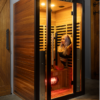 A beautiful model relaxing in Mirna two person infrared sauna, wrapped in titanium and beautiful red cedar