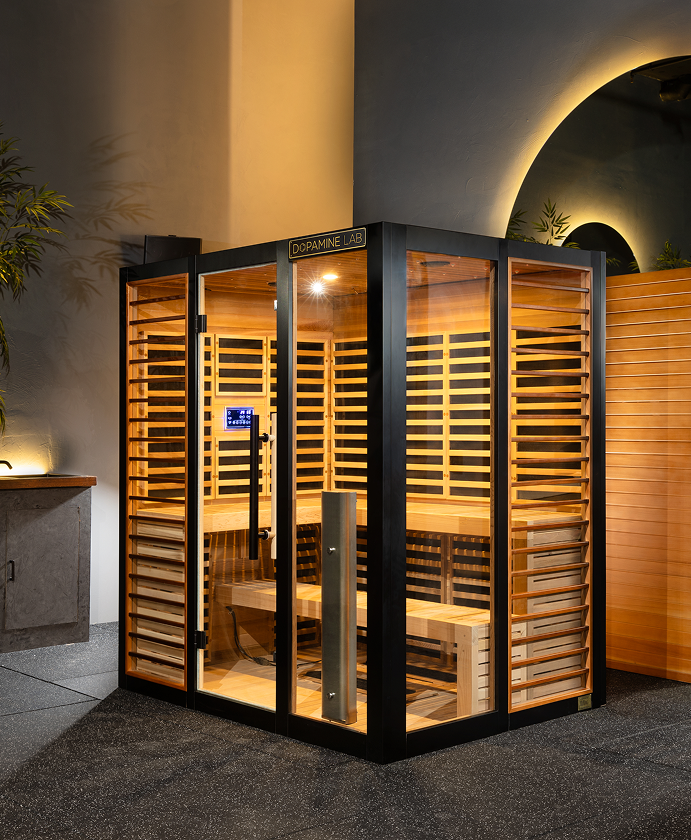 Obnova 4-5 person infrared sauna showcasing the beautiful red cedar interior and exterior wall wrapped in black titanium