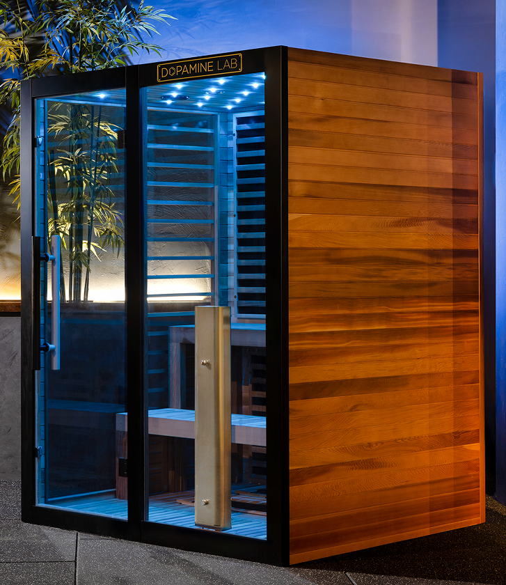 VATRA 3-4 PERSON SAUNA showcasing the deep red cedar exterior, blue chromotherapy lights and glass side